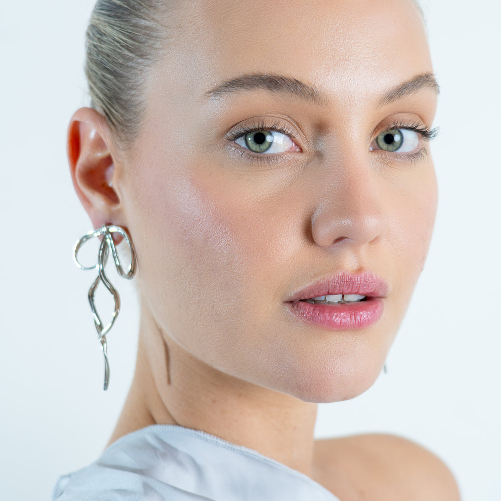 
                      
                        We Are Emte- Bow Studs in Silver
                      
                    